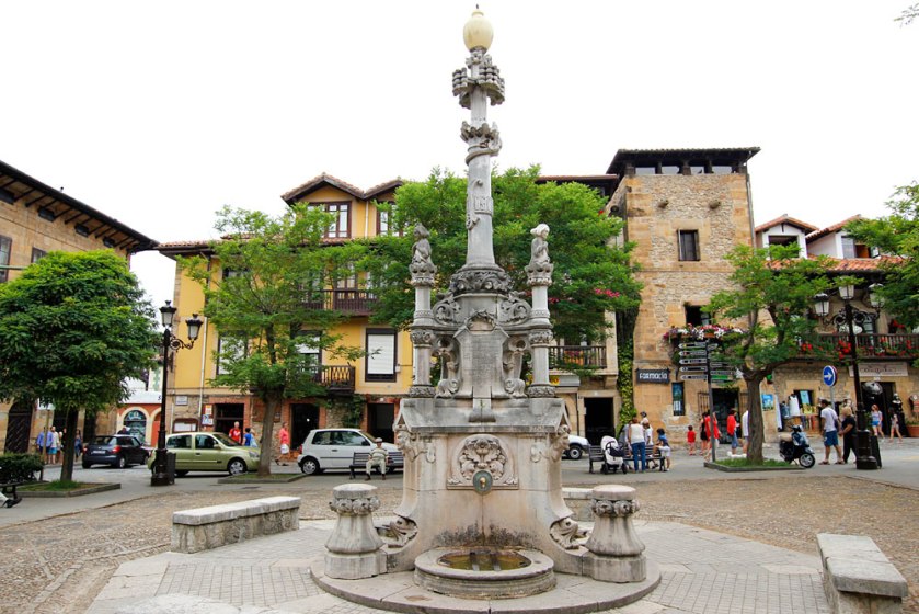 Fuente de los Tres Caños (1899) La Fuente de los Tres Caños es levantada en la plaza con el mismo nombre y proyectada por Lluís Domènech i Montaner en homenaje a Joaquín de Piélago, hijo político del marqués de Comillas, por conseguir la traída de aguas a la villa.  El conjunto escultórico, que destaca por sus motivos vegetales -especialmente las cenefas florales- y figuraciones de ángeles, plantea una columna central sobre una base tripartita y una fuente en cada uno de los tres lados. Otros motivos ornamentales son un delfín enroscado, que supone el tema central, una cruz patada con botones en sus extremos, y textos de agradecimiento.