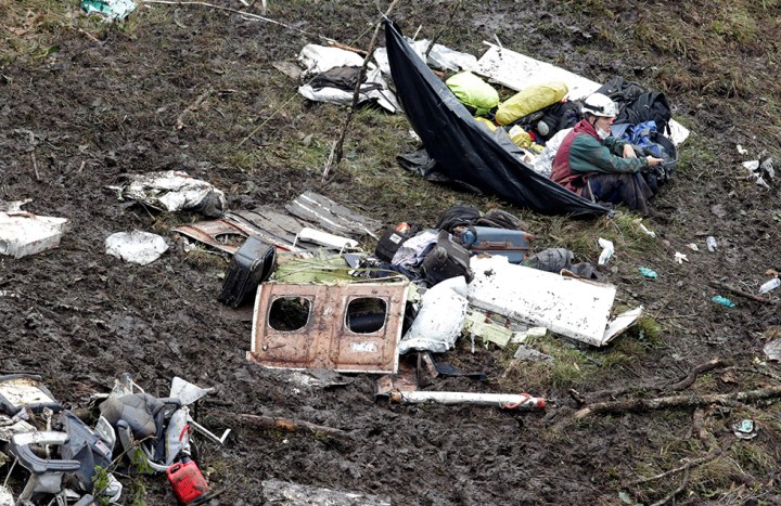 A rescue worker sits near the wreckage of a plane that crashed into the Colombian jungle with Brazilian soccer team Chapecoense onboard near Medellin